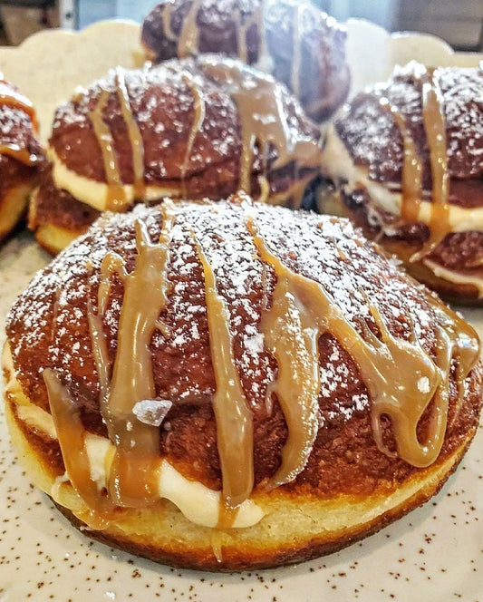 Paçzki style filled donut with dulce de leche cream filling and caramel drizzle on top